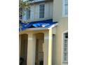 Beige two-story house with a covered entryway and a tarp on the roof at 4909 Larkenheath Dr, Spring Hill, FL 34609