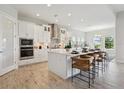 Bright kitchen featuring white cabinets, stainless appliances, a decorative backsplash, and a large center island at 17721 Roost Pl, Lakewood Ranch, FL 34211