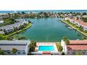 Aerial view of a waterfront community showcasing a pool, canal access, and nearby beach at 12246 2Nd E St # 503, Treasure Island, FL 33706