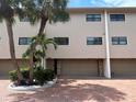 Three-story townhome featuring an attached garage, brick driveway, and tropical landscaping at 12246 2Nd E St # 503, Treasure Island, FL 33706