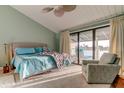 Bright primary bedroom featuring a water view balcony, ceiling fan, and cozy armchair at 12246 2Nd E St # 503, Treasure Island, FL 33706