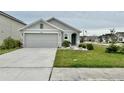 Front view of a one story gray house with a two car garage at 7855 Davie Ray Dr, Zephyrhills, FL 33540