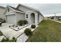 Gray one-story house with a two-car garage and landscaped front yard at 7855 Davie Ray Dr, Zephyrhills, FL 33540