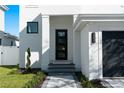 Modern home featuring a sleek front door, gray paver steps, and minimalist landscaping at 2355 Bahia Vista St, Sarasota, FL 34239