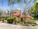 Two-story house with red tile roof and lush landscaping at 5359 Saddlebrook Way, Wesley Chapel, FL 33543