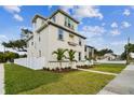 A three-story house with light beige siding, palm trees, and a white fence at 1323 W Arch St, Tampa, FL 33607