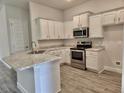 Modern kitchen featuring white cabinets, stainless steel appliances, and granite countertops at 13203 Ogden Glade Rd, Dade City, FL 33525