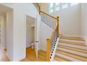 Elegant staircase with wood railings and a half bath underneath at 3659 Tea Leaf Aly, Land O Lakes, FL 34638