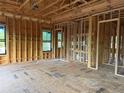 Spacious bedroom under construction with framed walls, windows, and floor underlayment at 4642 W Longfellow Ave, Tampa, FL 33629