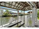 Covered boat lift, with a view of the neighborhood waterway and boat docks at 534 Estuary Shore Ln, Apollo Beach, FL 33572