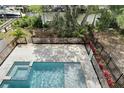 Aerial view of the private backyard with a modern pool, spa, lush landscaping and partial deck at 534 Estuary Shore Ln, Apollo Beach, FL 33572