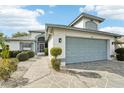 House exterior featuring a two-car garage and a stone paved walkway at 1830 E Del Webb Blvd, Sun City Center, FL 33573