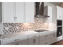 Modern kitchen featuring white cabinets, quartz countertops, and a sleek range hood at 11122 Rustic Timber Loop, San Antonio, FL 33576