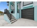 A close up view of a modern two-story home with a staircase, black railings, and a convenient two-car garage at 3171 Sea Grape Dr, Hernando Beach, FL 34607