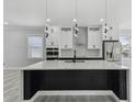 Modern kitchen featuring white cabinetry, a black waterfall island, and stainless steel appliances at 3380 Holly Springs Dr, Hernando Beach, FL 34607