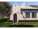 Charming home with an arched doorway, manicured landscaping, and a beautiful flowering tree at 5009 W Spring Lake Dr, Tampa, FL 33629