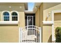 Front entry of home with arched windows, gate, and landscaping at 2121 Sifield Greens Way # 64, Sun City Center, FL 33573