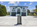Inviting two-story home showcasing a modern mailbox, double garages, and elevated entry with black railings at 3230 Azalea Drive # Lot 13, Hernando Beach, FL 34607