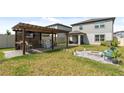 Large backyard with pergola, fire pit, and patio at 9358 Rally Spring Loop, Wesley Chapel, FL 33545