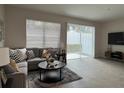 Living room with gray sectional sofa, coffee table and access to a patio at 11790 Blackbrook Ct, Seffner, FL 33584