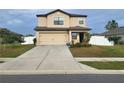 Two story house with beige siding and a two car garage at 6949 Crested Orchid Dr, Brooksville, FL 34602
