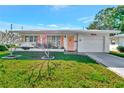 Front view of a single-story home with a neat lawn and attached garage at 9622 41St N Way, Pinellas Park, FL 33782