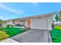 Landscaped yard with a white single-story home and attached garage at 9622 41St N Way, Pinellas Park, FL 33782