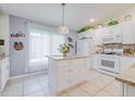 Modern kitchen with white cabinets, granite island, and stainless steel appliances at 7532 Regents Garden Way, Apollo Beach, FL 33572