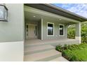 Inviting front porch with beige door and steps leading to the entrance at 156 Haddock Dr, Rotonda West, FL 33947
