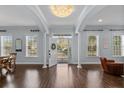 Bright foyer featuring hardwood floors, an elegant chandelier, and an open doorway leading to the outside at 5002 W Homer Ave, Tampa, FL 33629