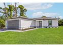 Single-story house with gray garage door and landscaping at 13371 Drysdale Ave, Port Charlotte, FL 33981