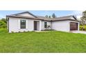 Single-story home with a two-car garage and lush green lawn at 6022 Gillot Blvd, Port Charlotte, FL 33981