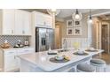 Modern kitchen with white cabinets, large island, stainless steel appliances, and stylish backsplash at 10571 Piedra Dr, Palmetto, FL 34221
