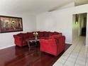 Living room with red sectional sofa and hardwood floors at 28509 Meadowrush Way, Wesley Chapel, FL 33543