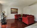 Living room boasts hardwood floors and a comfy sectional at 28509 Meadowrush Way, Wesley Chapel, FL 33543