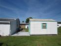 White storage shed with teal shutters at 37241 Cora Ave, Zephyrhills, FL 33542