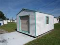 White storage shed with roll-up door and window at 37241 Cora Ave, Zephyrhills, FL 33542