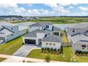 Modern house near a lake with a gray roof, white exterior, and a paver driveway at 32298 Wetland Bird Vw, San Antonio, FL 33576