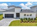 Modern two-story house with a white exterior, gray roof, and a paver driveway at 32298 Wetland Bird Vw, San Antonio, FL 33576