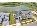 Modern house with a gray roof, white exterior, and a paver driveway, situated by a lake at 32298 Wetland Bird Vw, San Antonio, FL 33576