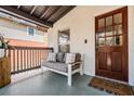 Cozy front porch featuring comfortable seating, a wood-framed railing, and an inviting wooden front door at 4304 W Laurel St, Tampa, FL 33607