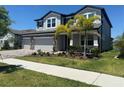 Two-story house with a three-car garage and well-manicured lawn at 12964 Willow Grove Dr, Riverview, FL 33579