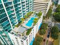 Aerial view of a luxurious rooftop pool with lounge area and palm trees at 777 N Ashley Dr # 2601, Tampa, FL 33602