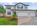 Two-story home with blue shutters and a brick paver driveway at 4939 Eagle Rock Dr, Wimauma, FL 33598