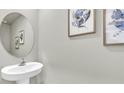Stylish powder room with pedestal sink and decorative artwork enhances this well-appointed home at 814 Flash Dr, Clearwater, FL 33765