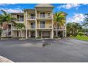 Multi-story condo building with private balconies, garages, and lush tropical landscaping at 3257 Mangrove Point Dr, Ruskin, FL 33570