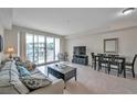Bright living room featuring tile floors, comfortable seating, and sliding glass doors to a balcony at 3257 Mangrove Point Dr, Ruskin, FL 33570