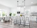 Modern white kitchen with an island, stainless steel appliances, and pendant lighting at 18078 Spartonvail Ave, Port Charlotte, FL 33954