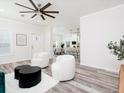 Open-concept living room with white accent chairs and a view into the kitchen at 18078 Spartonvail Ave, Port Charlotte, FL 33954