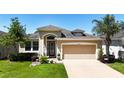 One-story house with tan exterior, attached garage, and landscaped lawn at 29405 Cochiti Lake Dr, San Antonio, FL 33576